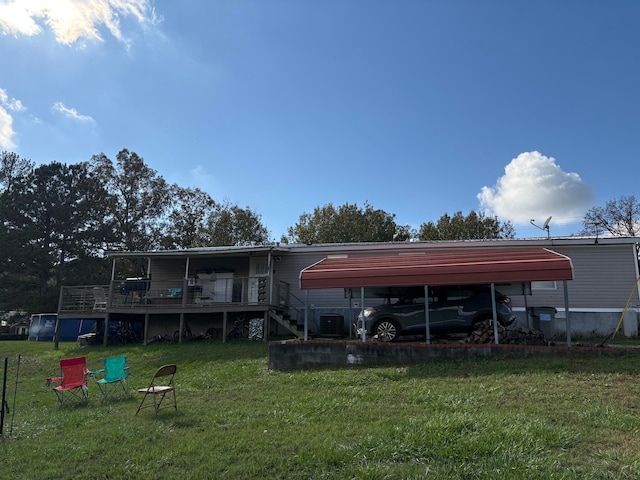 back of property featuring a carport and a yard