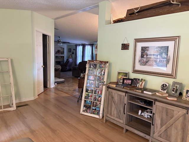 corridor with hardwood / wood-style floors and a textured ceiling