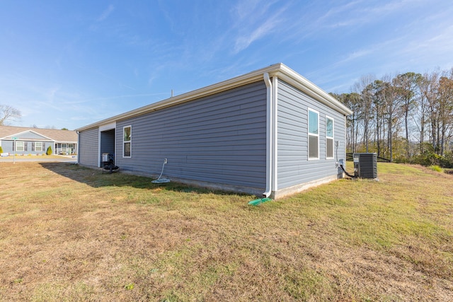 view of home's exterior featuring central AC unit and a lawn