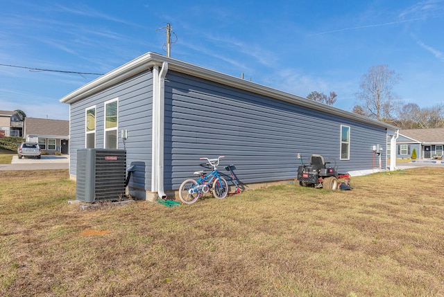 view of home's exterior with central AC unit and a lawn