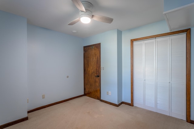 unfurnished bedroom featuring a closet, light colored carpet, and ceiling fan