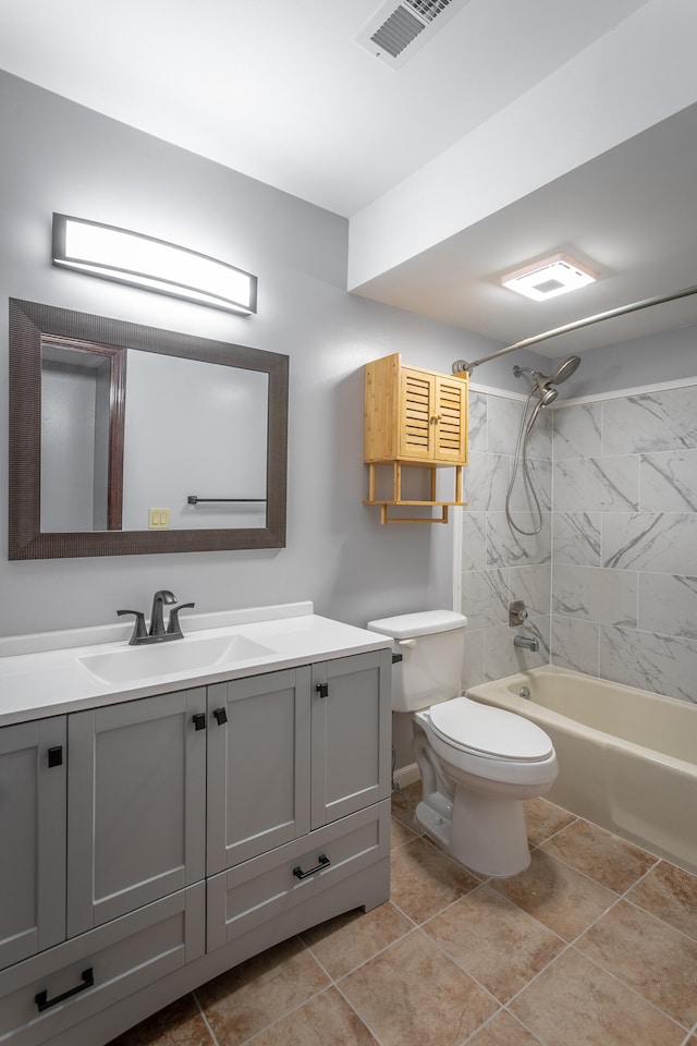 full bathroom with tile patterned flooring, vanity, tiled shower / bath combo, and toilet