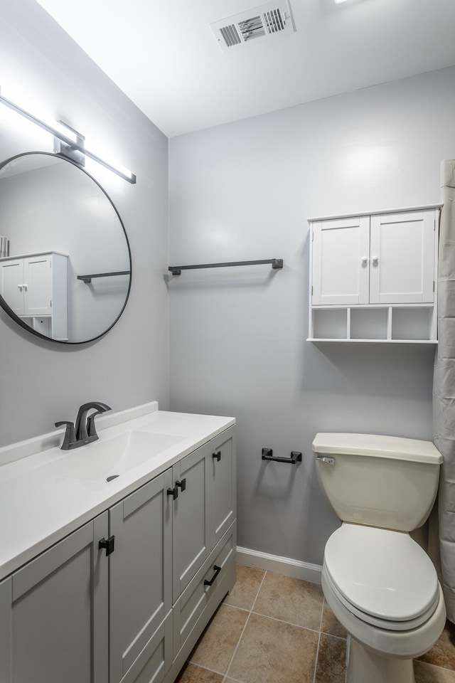 bathroom featuring toilet, vanity, and tile patterned flooring