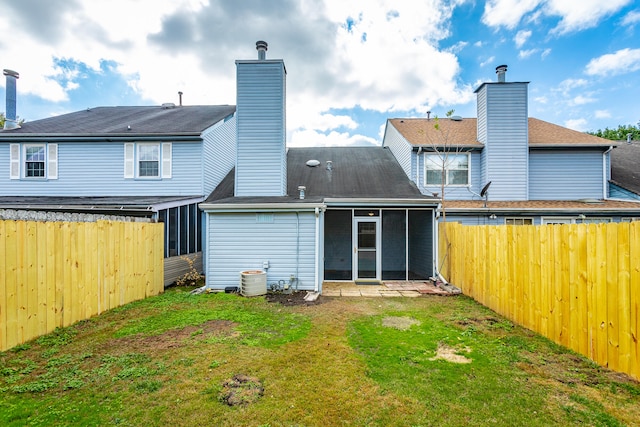 back of property featuring a lawn, a sunroom, and a patio