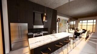 kitchen with dark brown cabinets, wall chimney exhaust hood, and stainless steel refrigerator