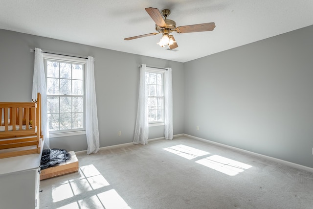 carpeted empty room featuring ceiling fan