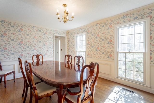 dining room featuring a notable chandelier, crown molding, and light hardwood / wood-style floors