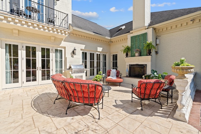 view of patio featuring a balcony, outdoor lounge area, a grill, and french doors