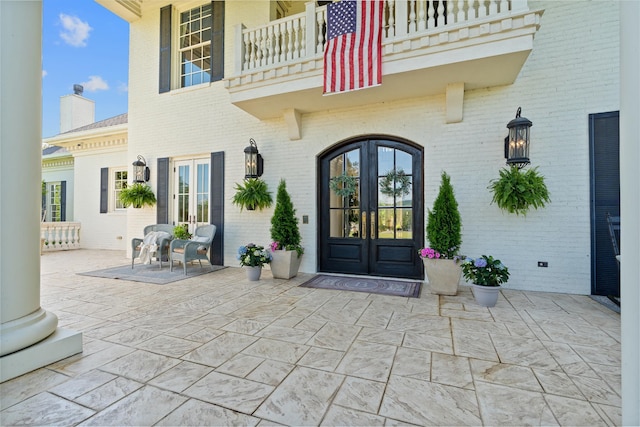 doorway to property with a balcony and french doors