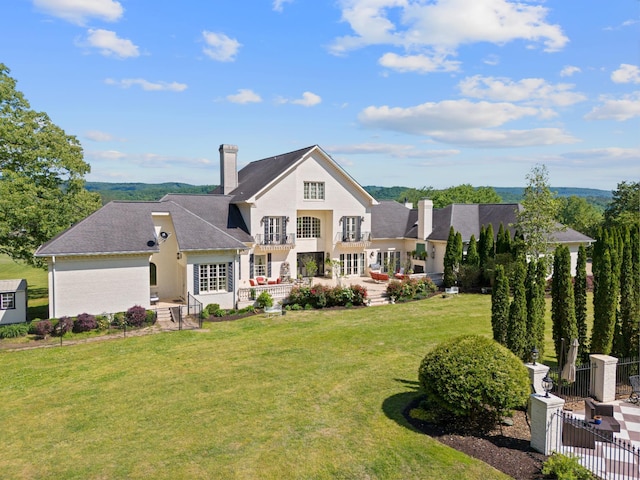 rear view of property featuring a lawn