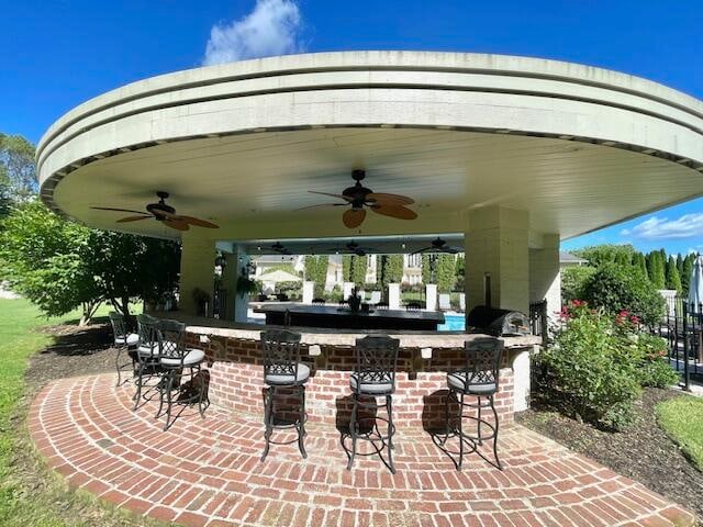 view of patio featuring an outdoor bar and ceiling fan