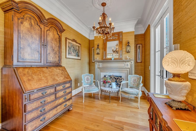 sitting room with ornamental molding, light hardwood / wood-style flooring, and a chandelier