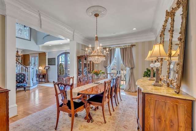 dining area with a healthy amount of sunlight, light wood-type flooring, french doors, and ornamental molding