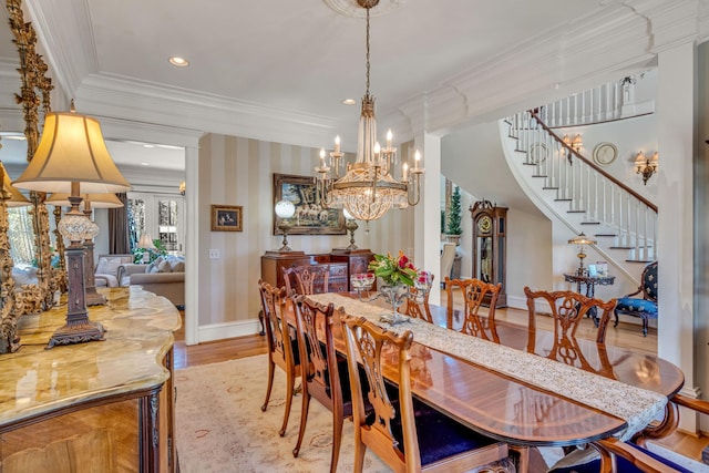 dining room featuring light wood-type flooring, a notable chandelier, and crown molding