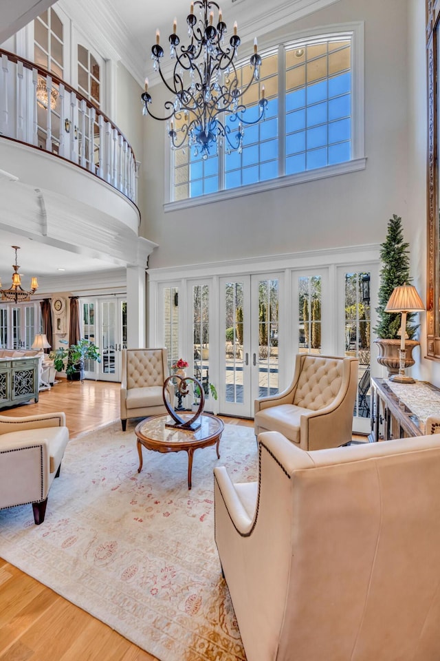 living room featuring hardwood / wood-style floors, a healthy amount of sunlight, french doors, and ornamental molding