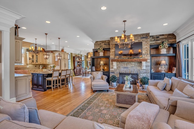 living room with a fireplace, light hardwood / wood-style flooring, and ornamental molding