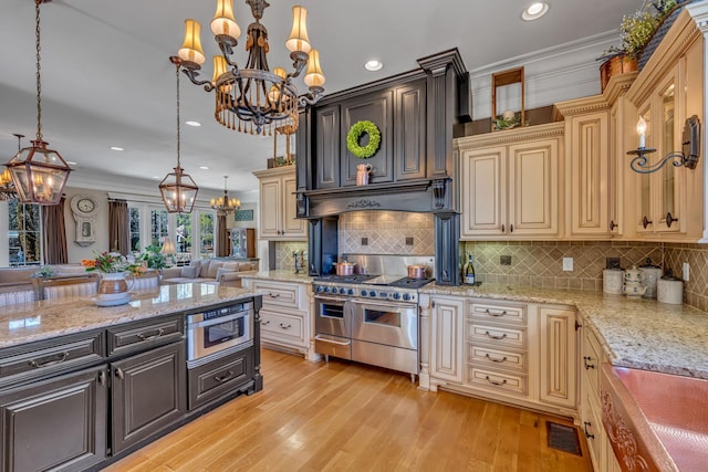 kitchen featuring pendant lighting, stainless steel appliances, light hardwood / wood-style floors, and crown molding