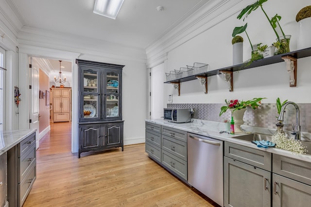 kitchen with tasteful backsplash, appliances with stainless steel finishes, gray cabinets, sink, and light hardwood / wood-style flooring