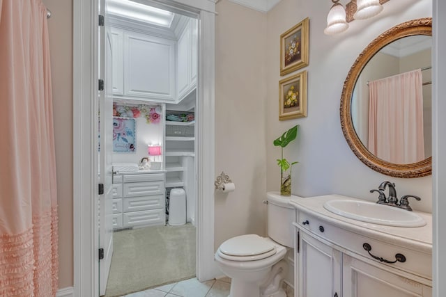 bathroom with toilet, vanity, tile patterned floors, and crown molding