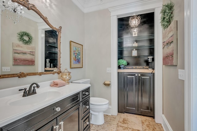 bathroom with ornamental molding, vanity, and toilet