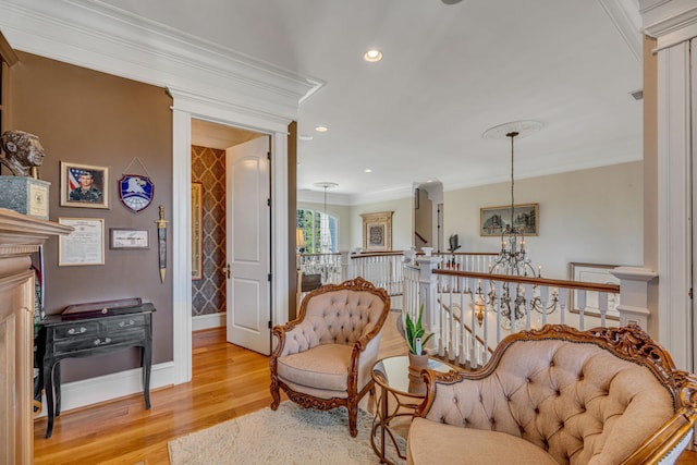 living area featuring an inviting chandelier, light wood-type flooring, and crown molding