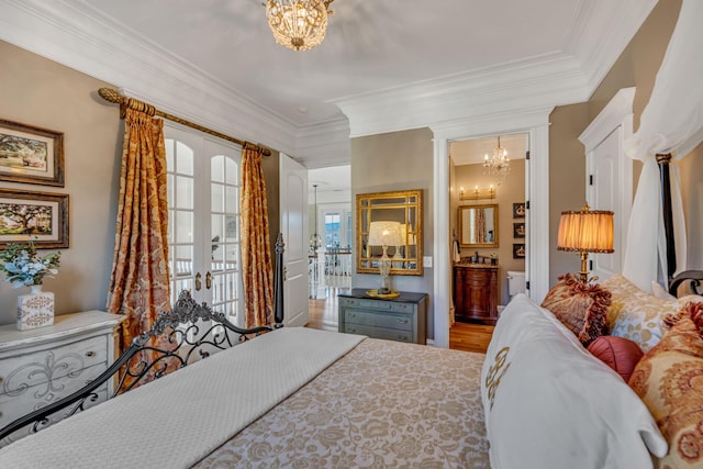 bedroom featuring french doors, ensuite bath, wood-type flooring, a chandelier, and ornamental molding