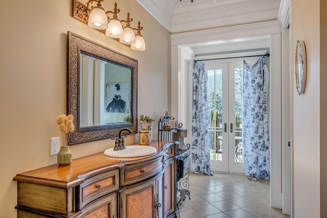 entryway featuring ornamental molding, french doors, sink, and light tile patterned floors