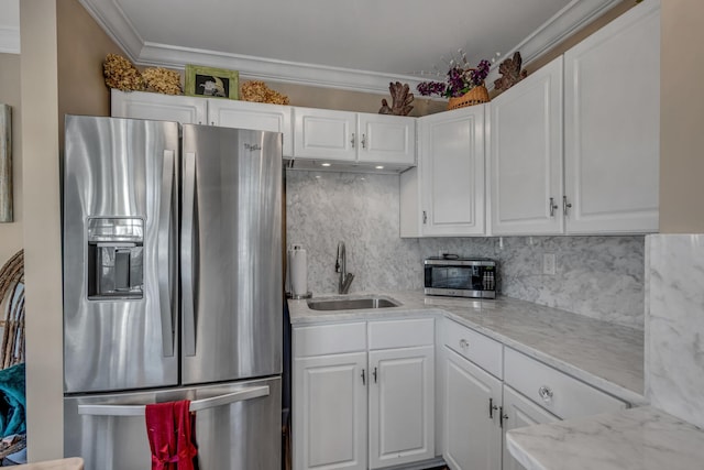 kitchen with sink, light stone counters, appliances with stainless steel finishes, ornamental molding, and white cabinets