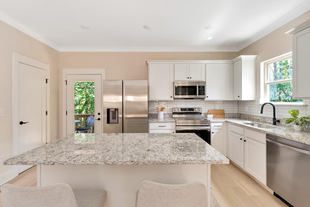 kitchen featuring a kitchen breakfast bar, plenty of natural light, sink, and appliances with stainless steel finishes