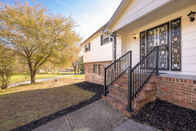 view of exterior entry with a yard