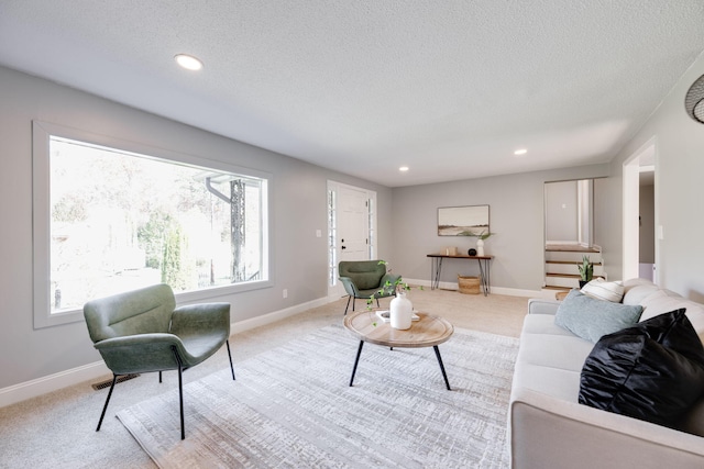 living room featuring light colored carpet and a textured ceiling