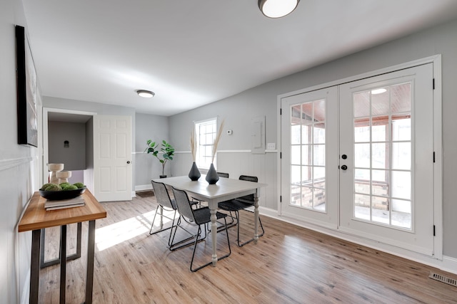 dining room with french doors and light hardwood / wood-style floors