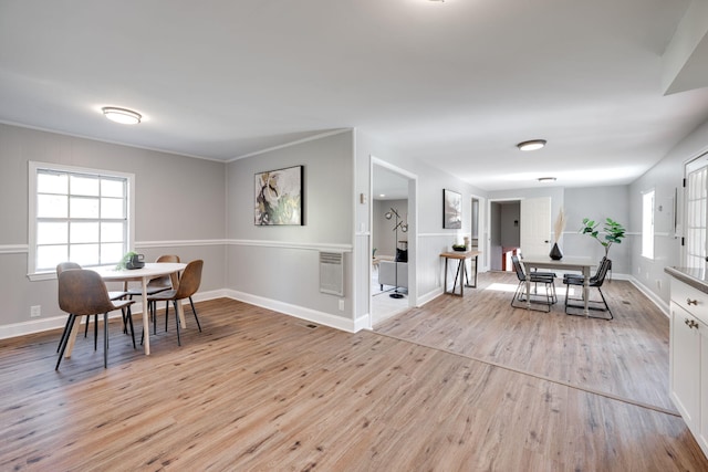 dining space with light hardwood / wood-style floors and heating unit