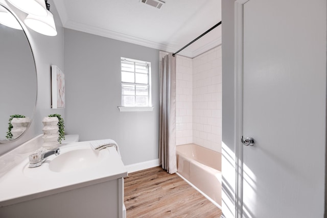 bathroom with hardwood / wood-style floors, vanity, ornamental molding, and shower / bath combo