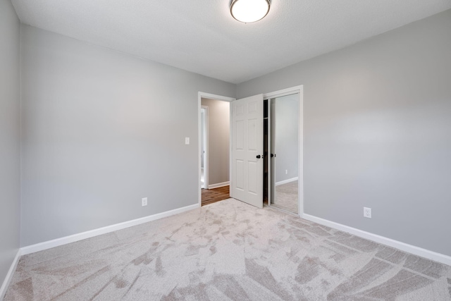 unfurnished bedroom featuring light carpet and a closet