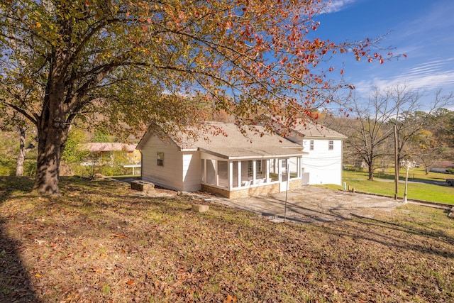 back of property featuring a lawn and a sunroom