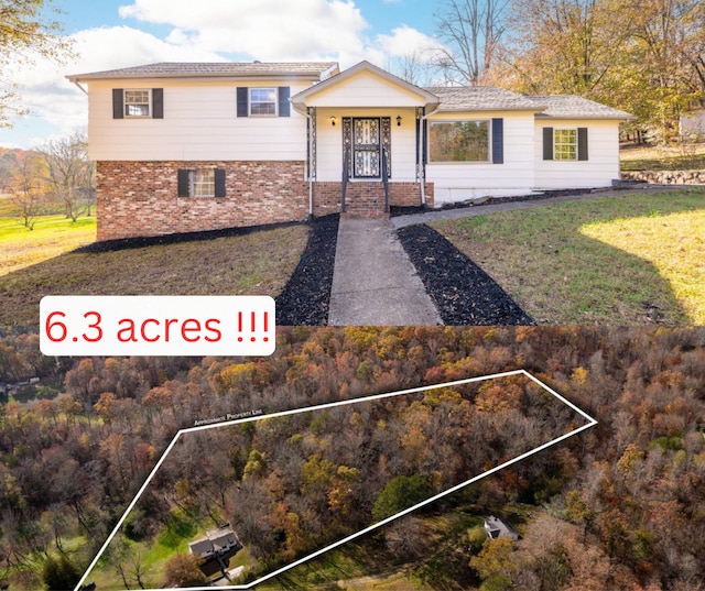 tri-level home featuring brick siding and a front lawn