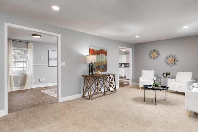 living area featuring a textured ceiling, baseboards, carpet flooring, and recessed lighting