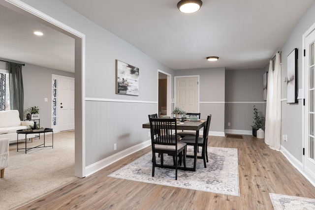 dining area featuring a wainscoted wall and light wood-type flooring