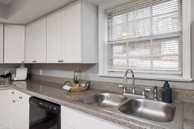 kitchen featuring plenty of natural light, black dishwasher, white cabinets, and a sink