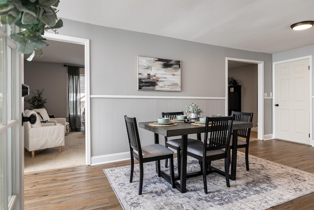 dining area featuring wainscoting and wood finished floors