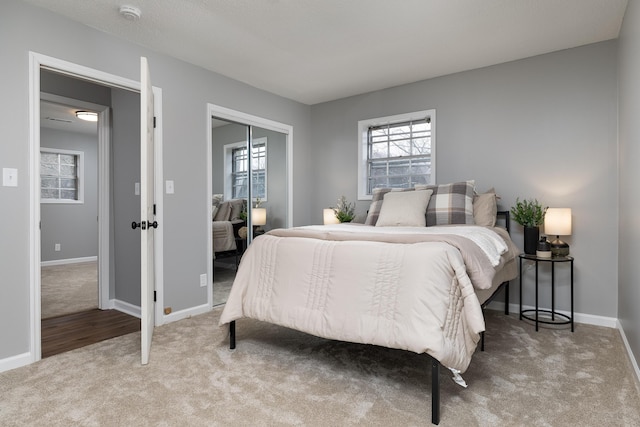 bedroom with a closet, multiple windows, and carpet flooring