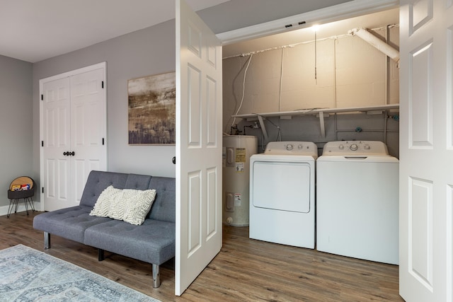 laundry room featuring laundry area, independent washer and dryer, wood finished floors, and electric water heater