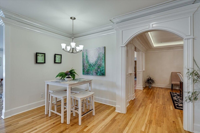 dining area with an inviting chandelier, ornamental molding, and light hardwood / wood-style flooring