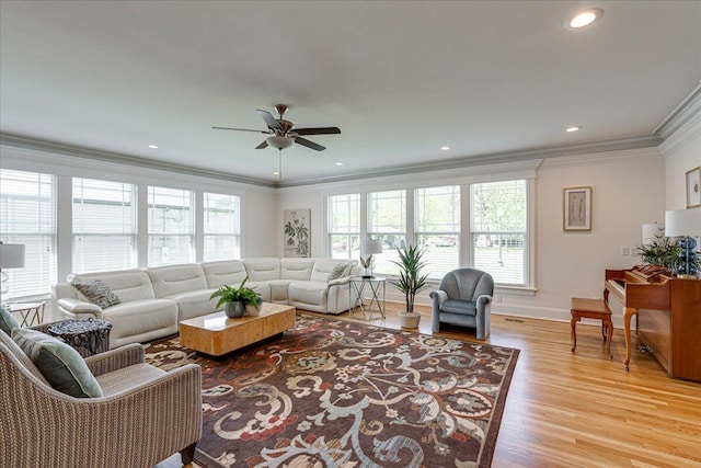 living room with crown molding, ceiling fan, and light hardwood / wood-style floors