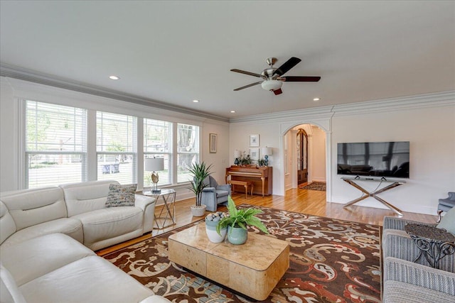 living room featuring light hardwood / wood-style floors, ceiling fan, and ornamental molding