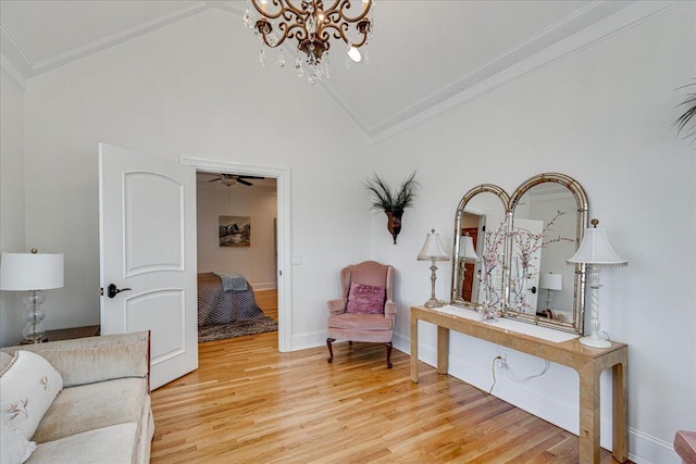 living area featuring hardwood / wood-style floors, ceiling fan with notable chandelier, crown molding, and high vaulted ceiling