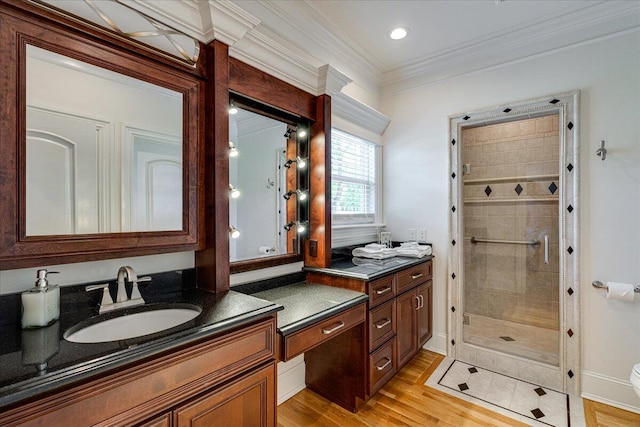 bathroom with vanity, an enclosed shower, wood-type flooring, and ornamental molding