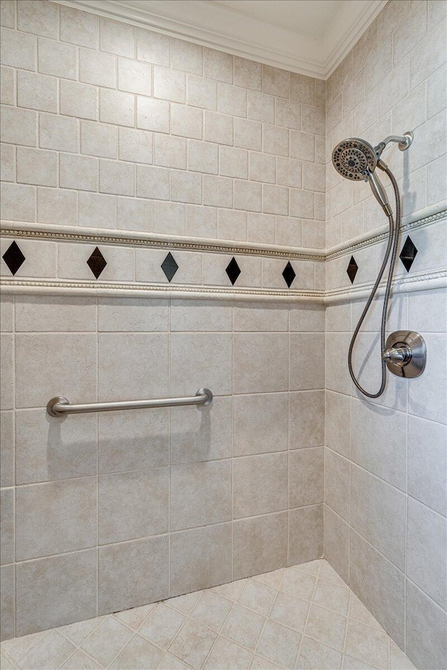 bathroom with tiled shower and ornamental molding