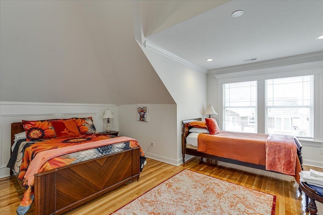 bedroom with light wood-type flooring and crown molding